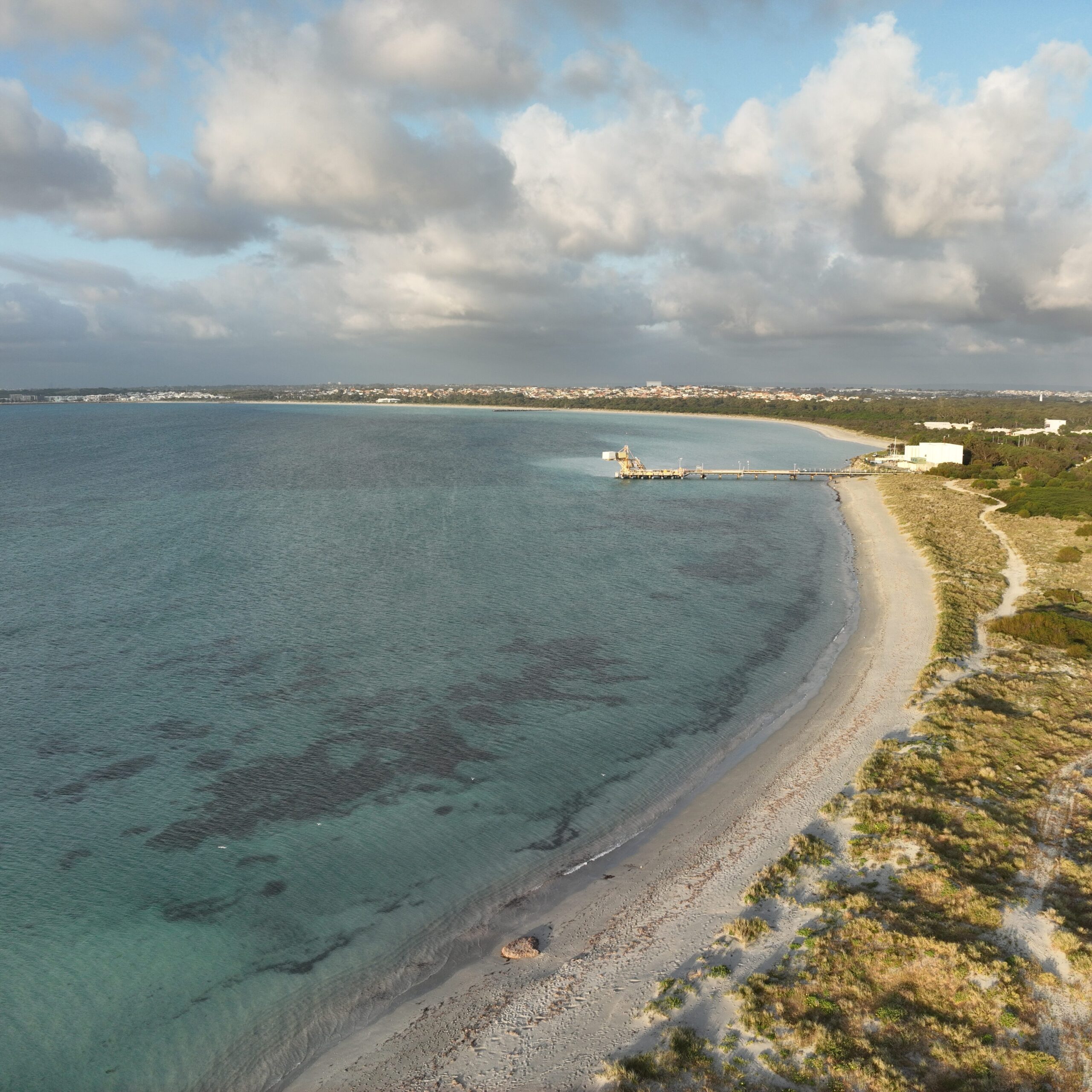 Cinematic aerial view of the Western Australian coastline, showcasing the natural beauty of the beach and shoreline through high-quality drone photography for visual storytelling and promotional use.